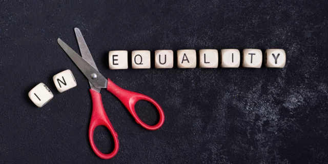 black background with scrabble letters that spell the work inequality. between in and equality there is a scissor.