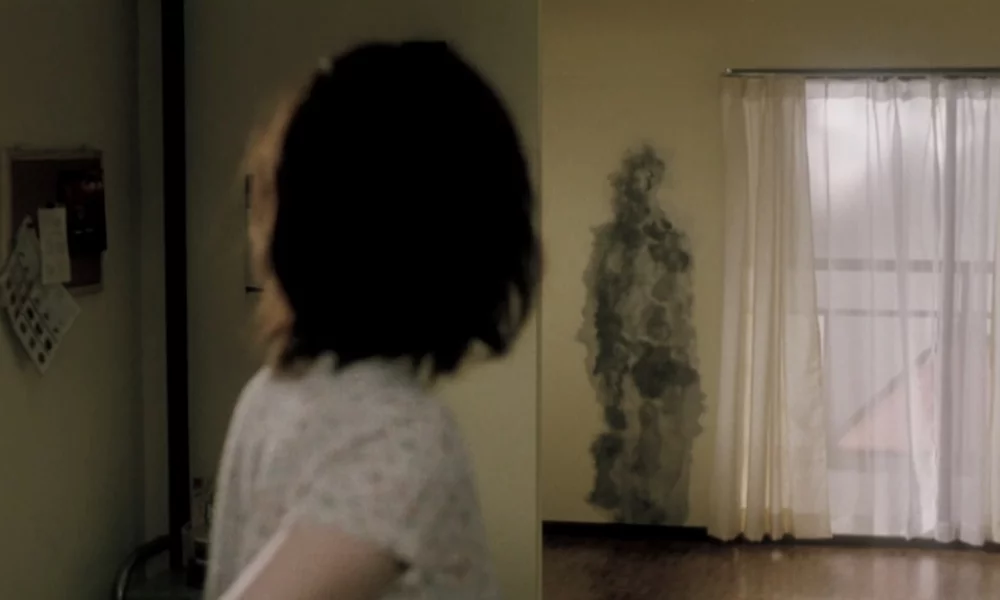 Pulse's main character Kudo Michi looks back at a human-shaped ash stain on the wall